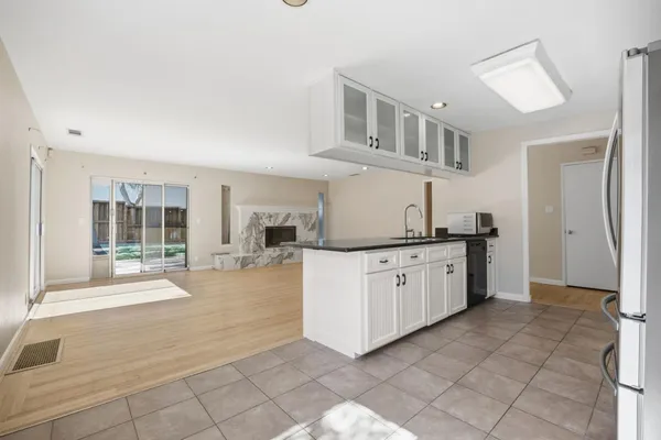 a open kitchen with cabinets a sink and a stove top oven