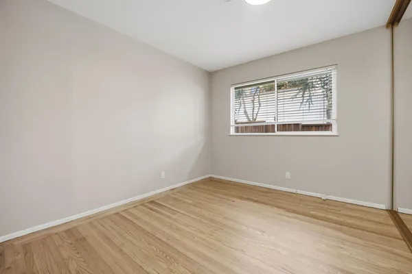 wooden floor in an empty room with a window