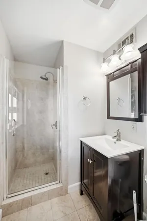 a bathroom with a sink shower and a mirror