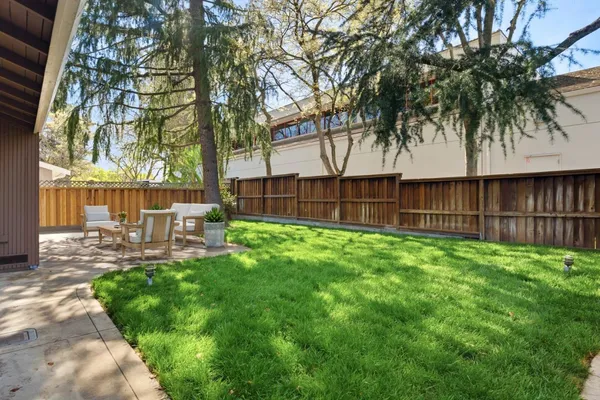 a view of a backyard with a garden and patio