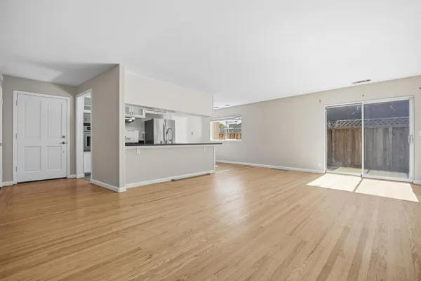 a view of empty room with wooden floor and door