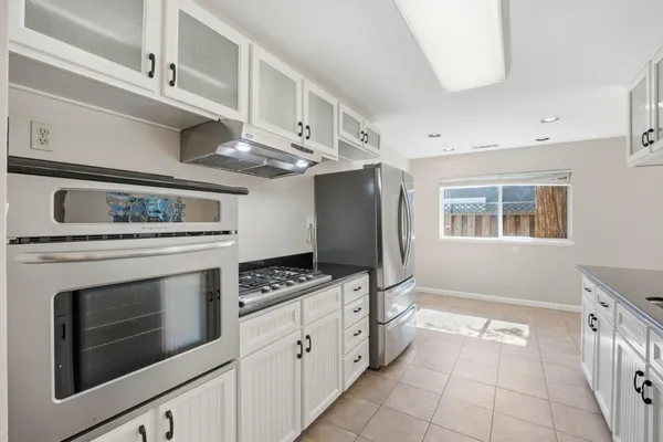 a kitchen with stainless steel appliances granite countertop a stove a washer and dryer
