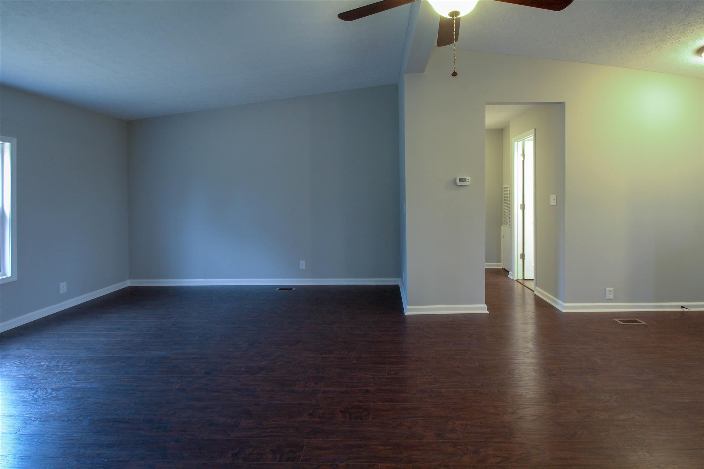 5647 Hopewell Road Springfield, TN 37172 - Photo 5 of 12 an empty room with wooden floor chandelier fan and windows