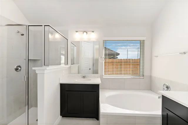 a bathroom with a bathtub shower and a sink