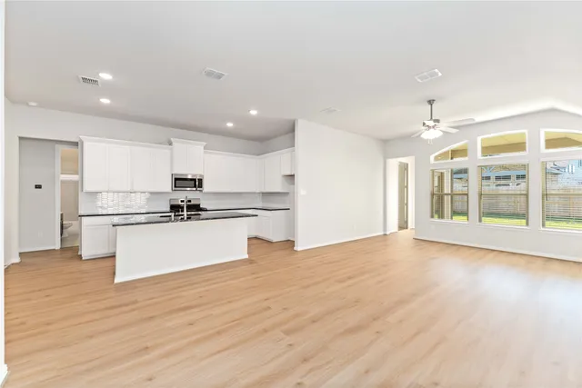 a view of kitchen with wooden floor and electronic appliances