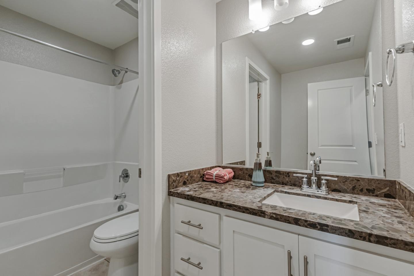 1633 Centre Pointe Drive Milpitas, CA 95035 - Photo 26 of 38 a bathroom with a granite countertop sink a toilet and a bathtub