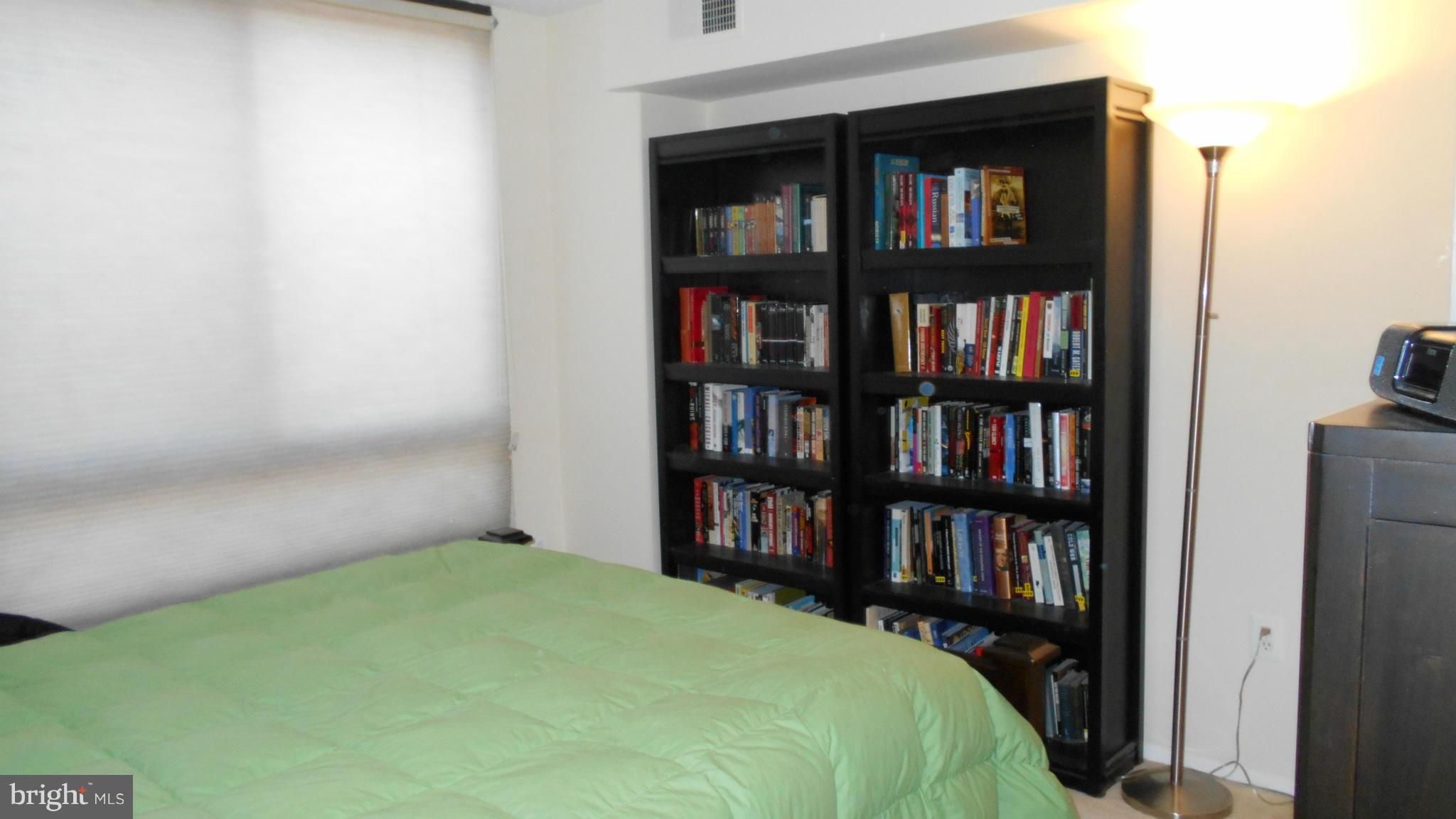 1808 Old Meadow Road, Unit 1003 McLean, VA 22102 - Photo 9 of 22 a bedroom with a bed and a book shelf