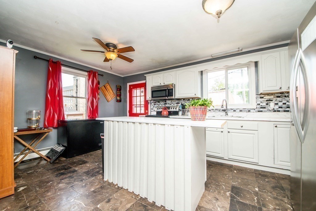 22 Michael Street, Unit 22 Fall River, MA 02721 - Photo 12 of 28 a kitchen with kitchen island granite countertop a stove a sink dishwasher and white cabinets with wooden floor