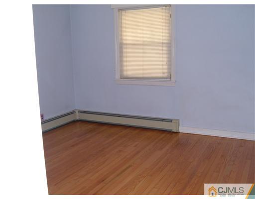 216 New Dover Road, Unit 216 Colonia, NJ 07067 - Photo 6 of 10 a view of a room with wooden floor and a window
