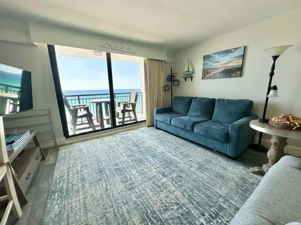 a living room with furniture and a floor to ceiling window