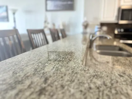 a kitchen with stainless steel appliances granite countertop a refrigerator a stove a sink and a microwave