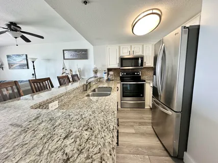 a kitchen with granite countertop white cabinets and stainless steel appliances
