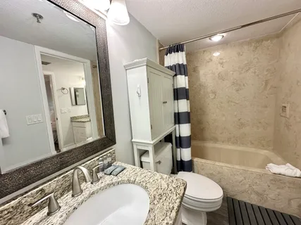 a bathroom with a granite countertop sink mirror and shower