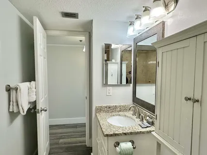a bathroom with a granite countertop toilet sink and mirror