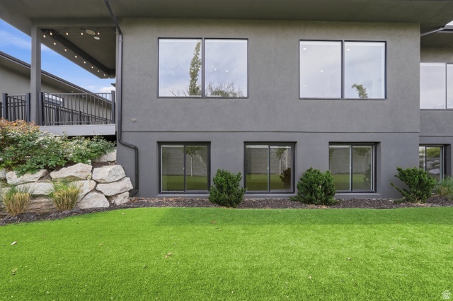 653 East Vandalay Lane Draper, UT 84020 - Photo 46 of 61 Rear exterior featuring a covered deck, stone retaining wall, and a low-maintenance artificial turf lawn