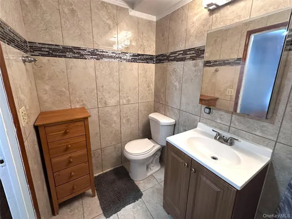 a bathroom with a sink a toilet a mirror and shower