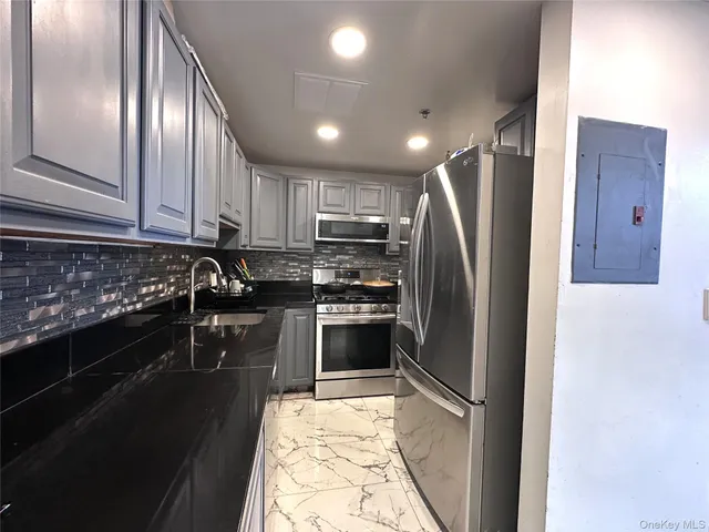 a kitchen with granite countertop stainless steel appliances and refrigerator