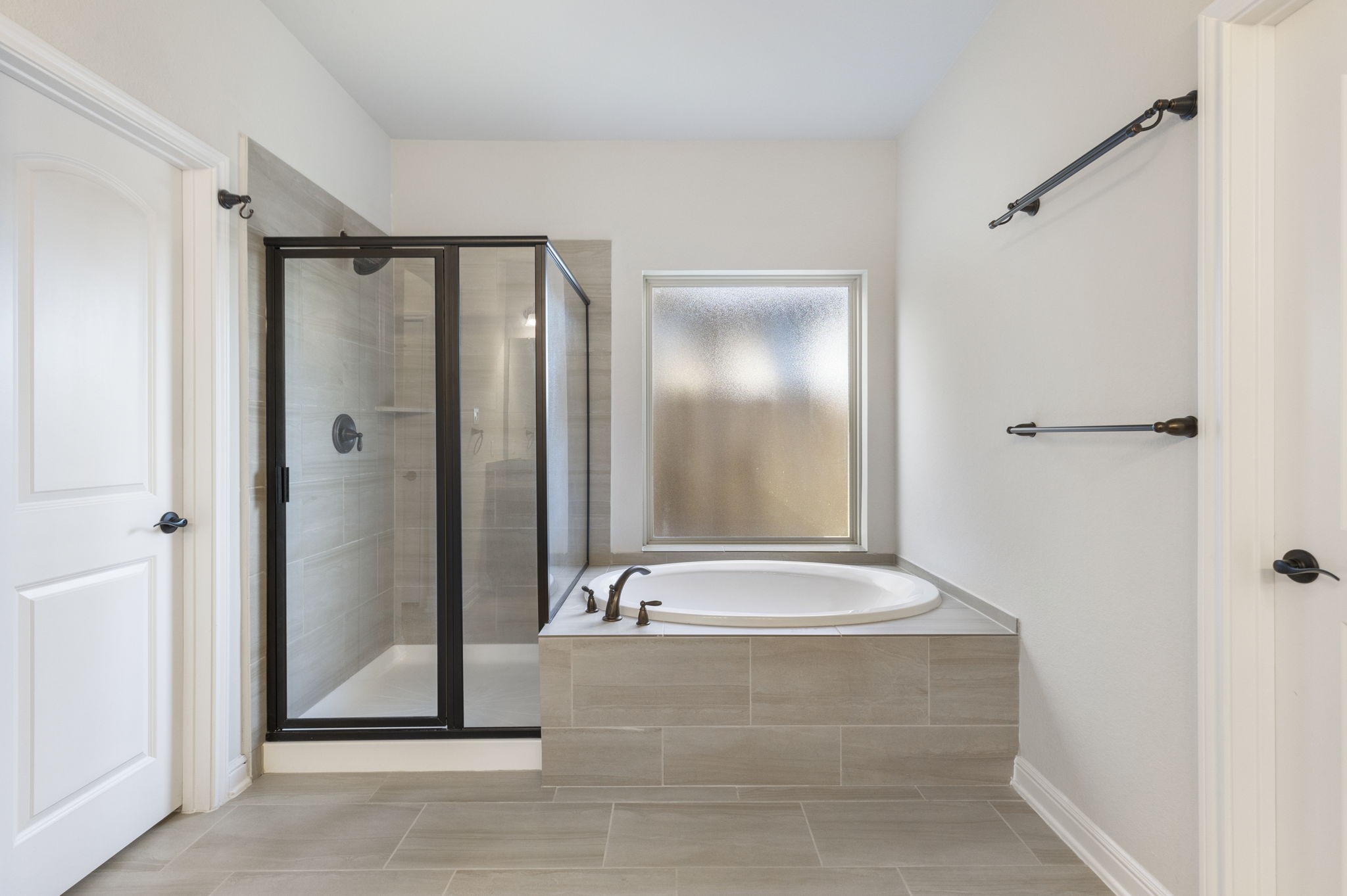 2819 Bradbury Hills Road Spring, TX 77373 - Photo 32 of 50 Discover serenity in this primary bathroom, featuring a sleek glass-enclosed shower and a luxurious soaking tub, all bathed in soft, natural light.