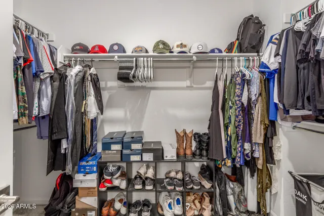 a view of walk in closet with clothes and shoes
