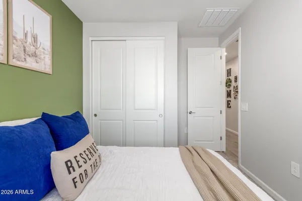 a bedroom with a bed and a painting on the wall