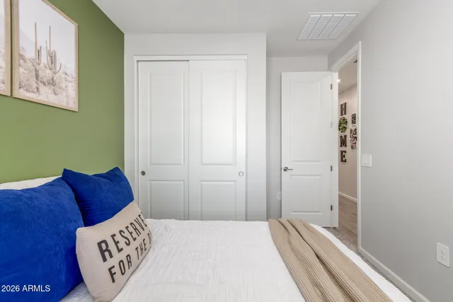 a bedroom with a bed and a painting on the wall