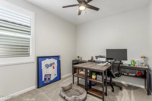 a view of a workspace with furniture and a window