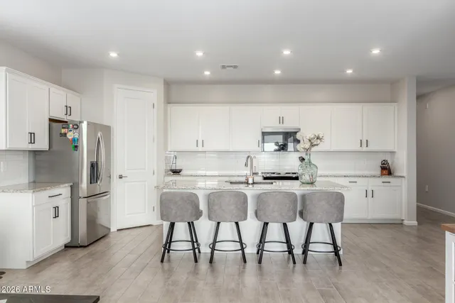 a kitchen with stainless steel appliances granite countertop a white cabinets and a refrigerator