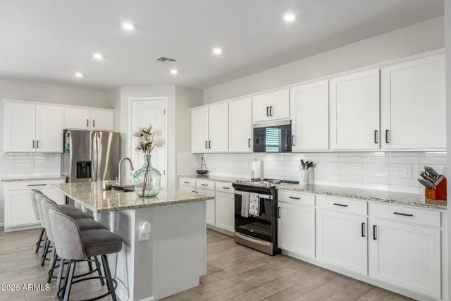 a kitchen with appliances a sink and cabinets