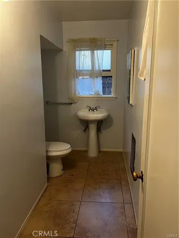 a bathroom with a sink toilet and window