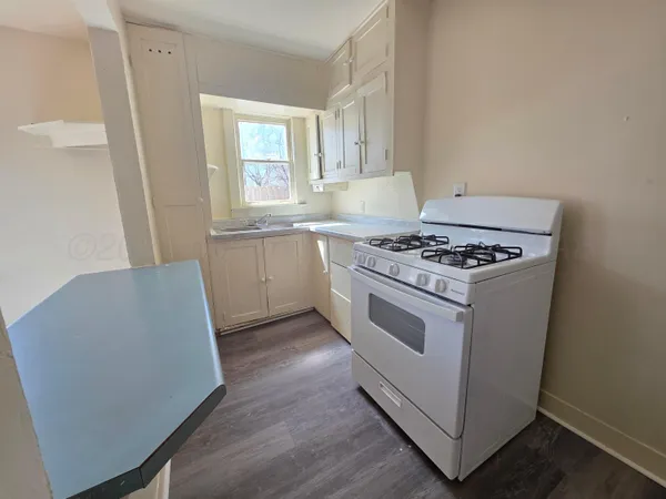 a white stove top oven sitting inside of a kitchen