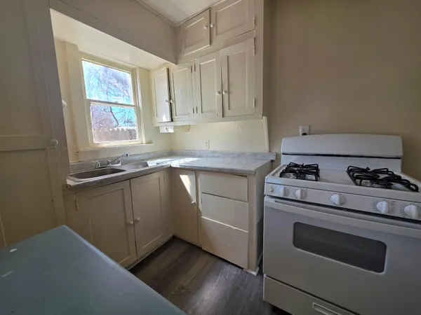 a kitchen with granite countertop cabinets stainless steel appliances and a window