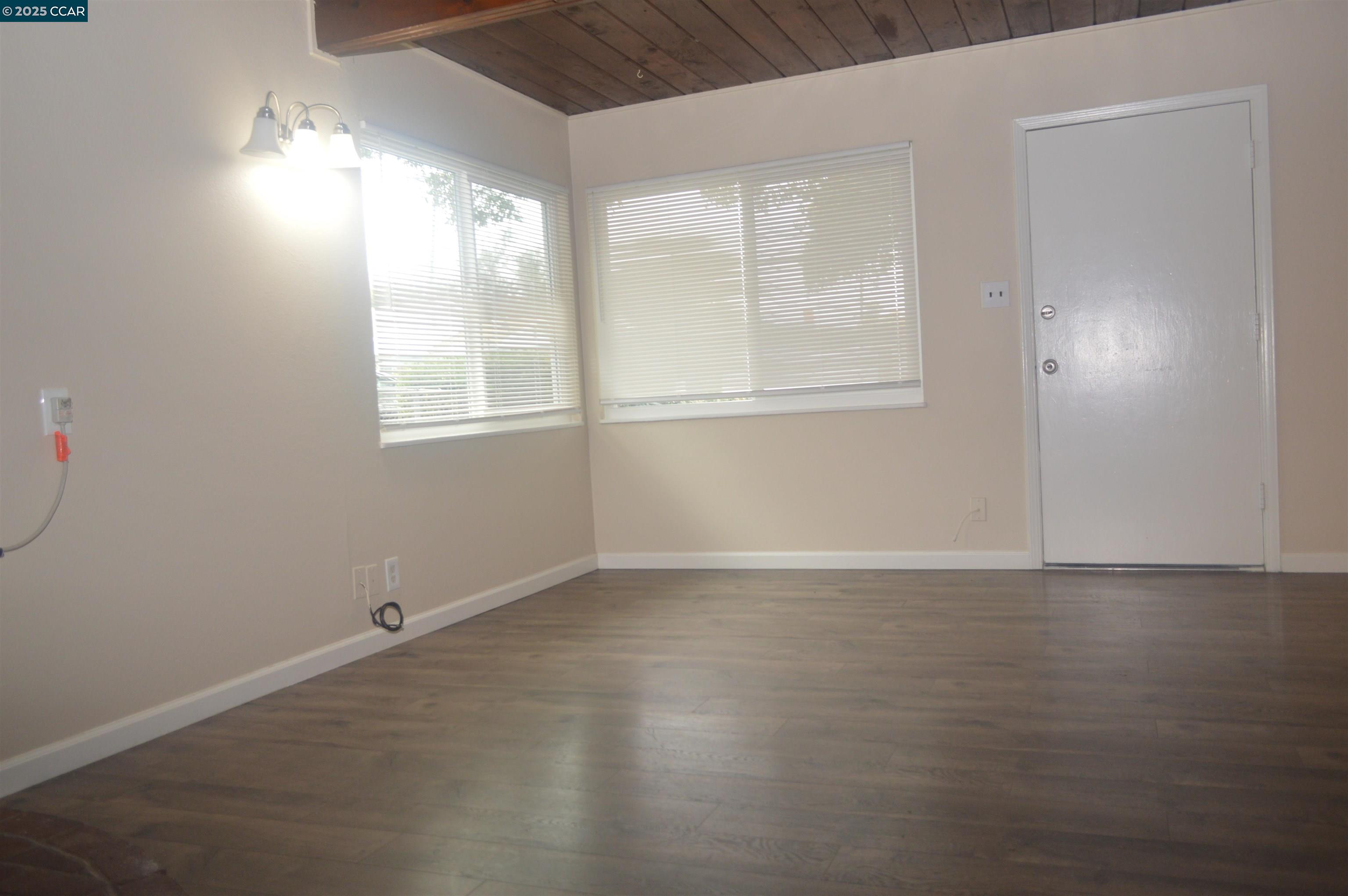 92 Beach Drive Bay Point, CA 94565 - Photo 4 of 19 an empty room with wooden floor and windows