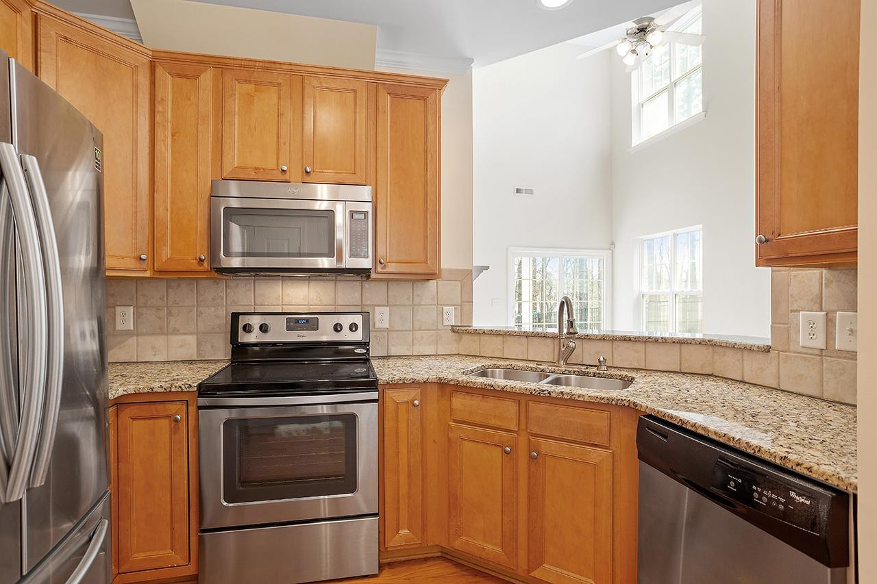 3317 Silver Star Drive Durham, NC 27713 - Photo 11 of 25 a kitchen with granite countertop a stove sink microwave and refrigerator