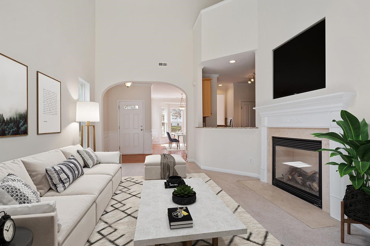 3317 Silver Star Drive Durham, NC 27713 - Photo 7 of 25 a living room with furniture a flat screen tv and a fireplace