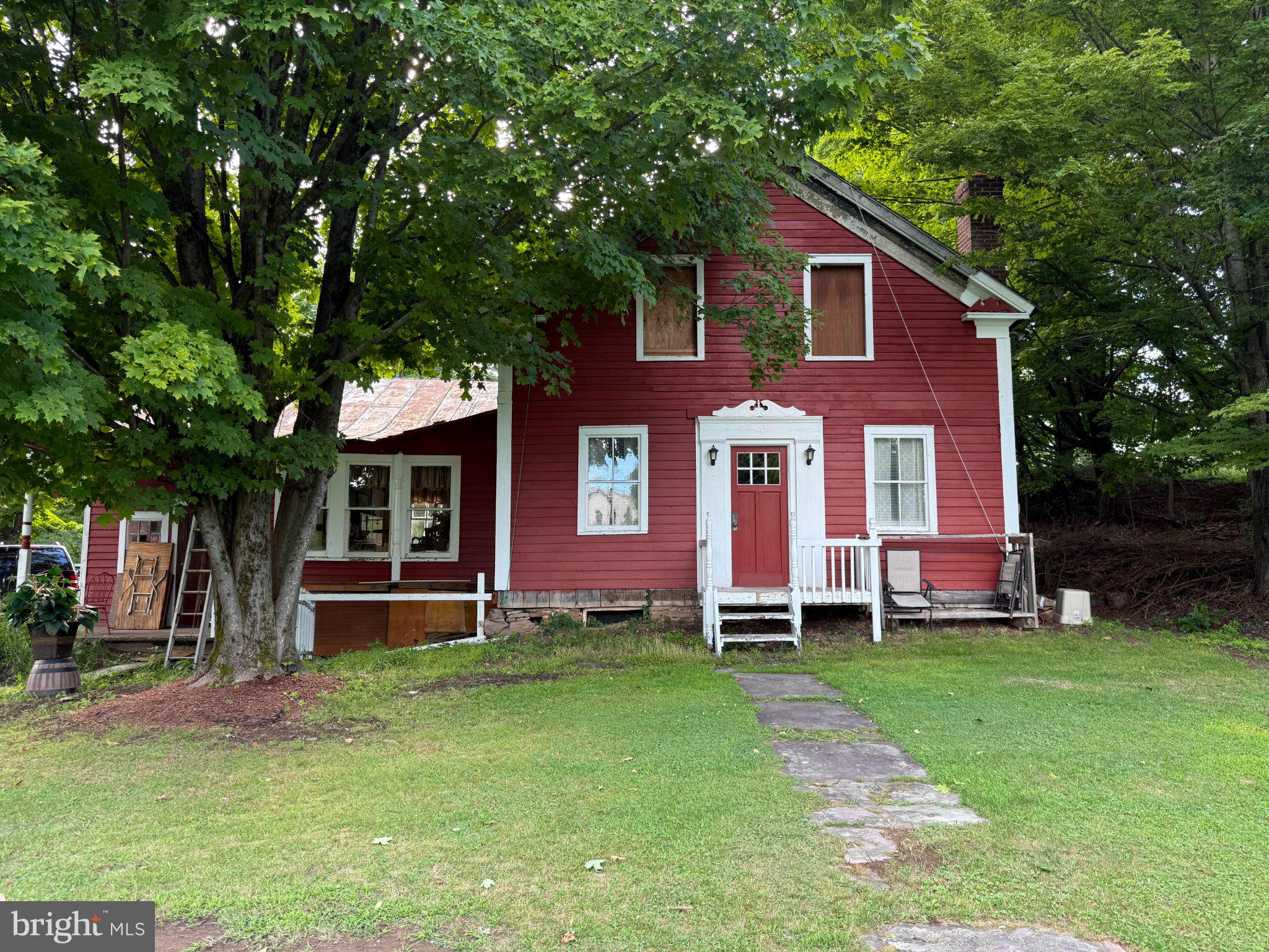 87 Milanville Road Beach Lake, PA 18405 - Photo 51 of 63 Charming red farmhouse with lush greenery.