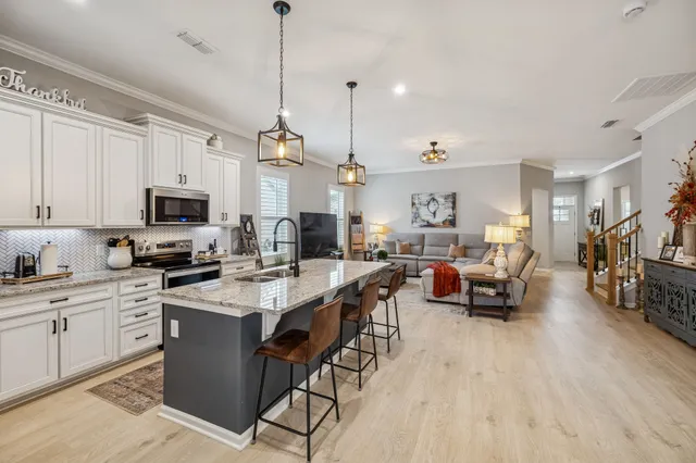 a open kitchen with stainless steel appliances granite countertop a stove and a wooden floors