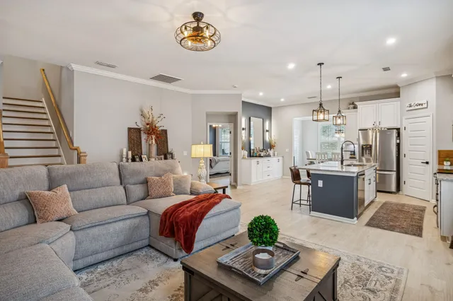 a living room with furniture and kitchen view