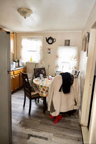 a living room with a table chairs and a refrigerator