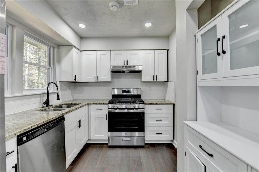 2853 Franklin Road Southwest Lawrenceville, GA 30044 - Photo 14 of 40 a kitchen with stainless steel appliances granite countertop a sink stove and cabinets