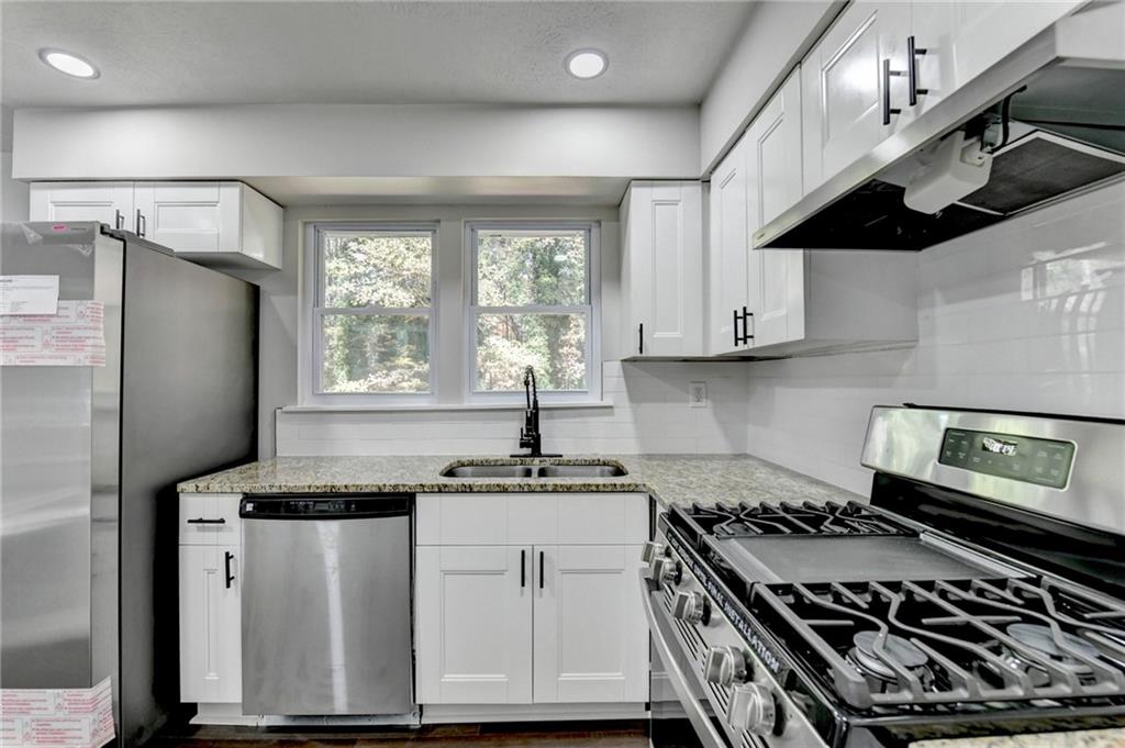 2853 Franklin Road Southwest Lawrenceville, GA 30044 - Photo 16 of 40 a kitchen with kitchen island granite countertop stainless steel appliances a sink stove and refrigerator