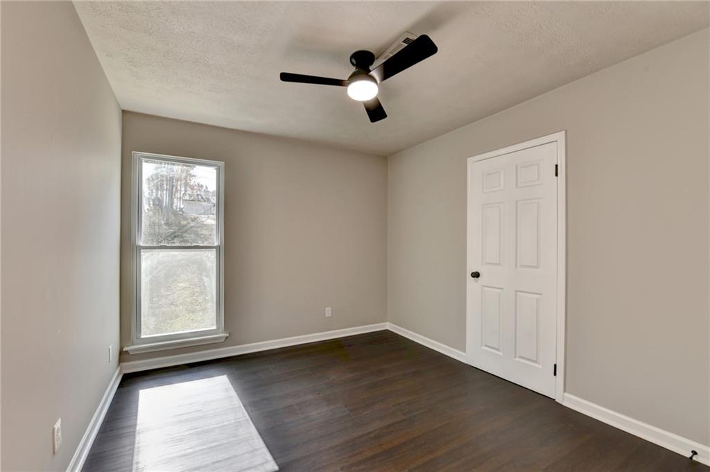 2853 Franklin Road Southwest Lawrenceville, GA 30044 - Photo 30 of 40 an empty room with wooden floor chandelier fan and windows