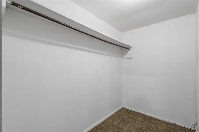 a view of an empty room with closet and a window