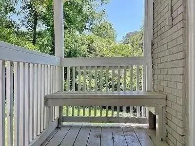 a view of a livingroom with a refrigerator wooden floor and a window