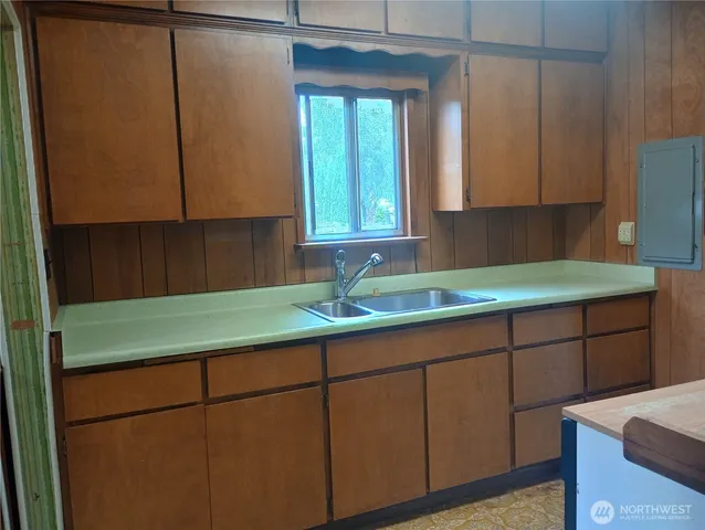 a kitchen with a sink window and cabinets