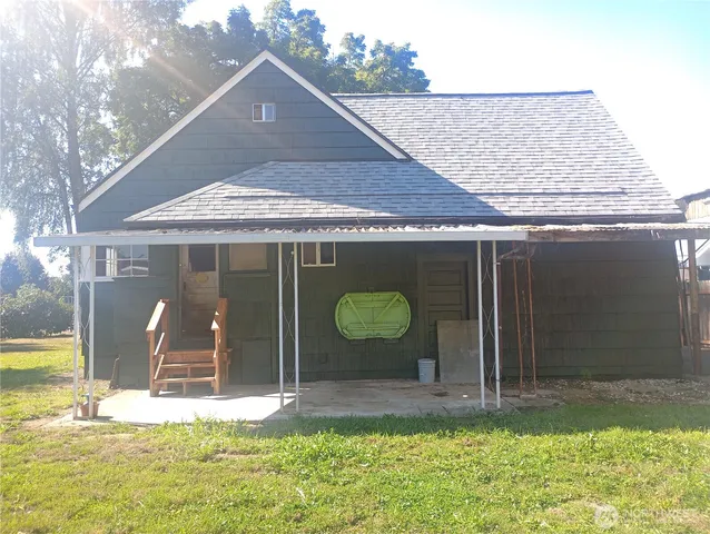 a view of a barn in front of a house with yard