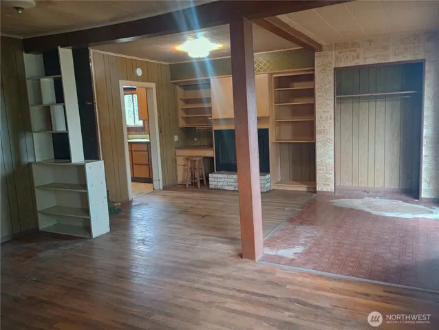 an empty room with wooden floor and closet