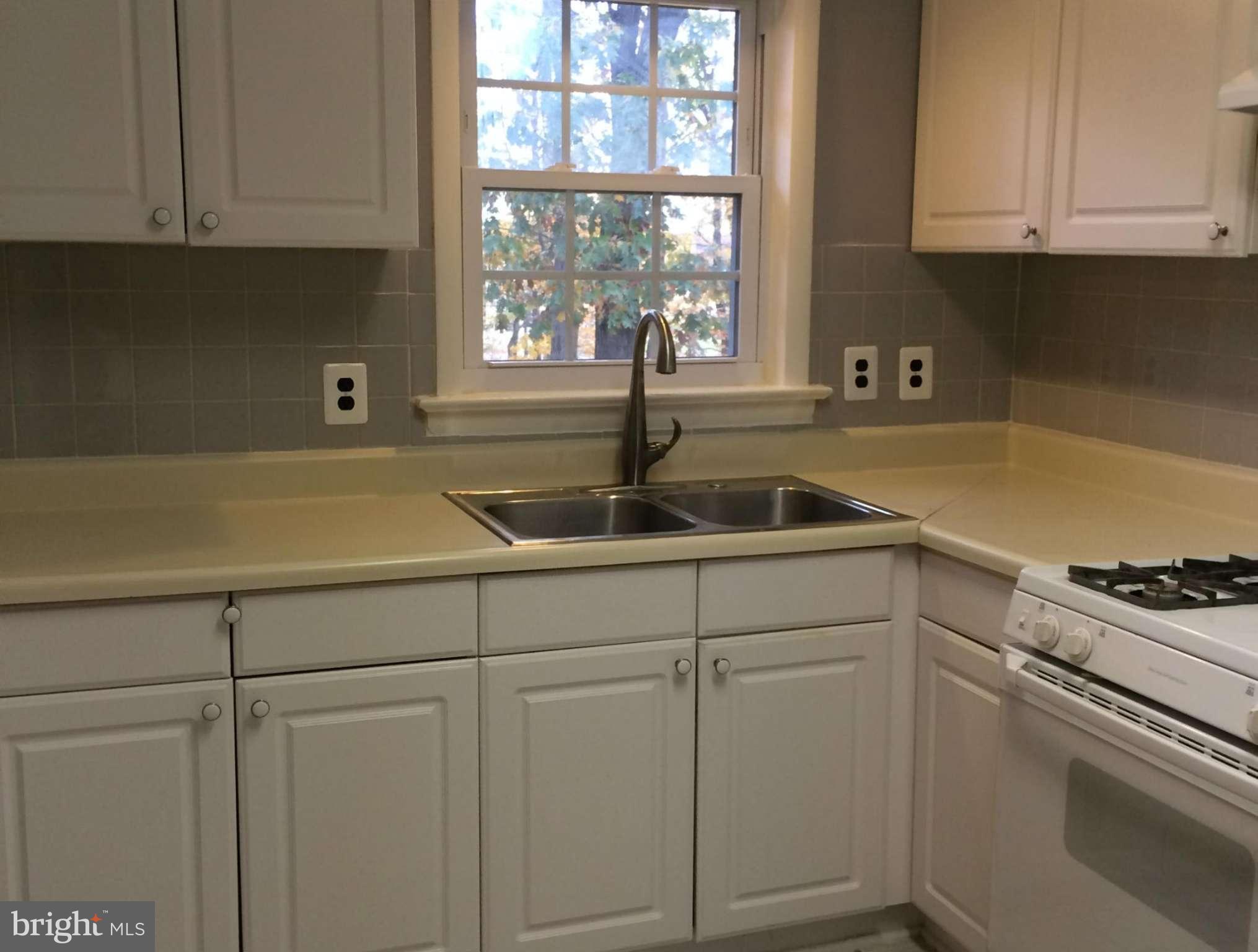 6814 Mayo Court Springfield, VA 22150 - Photo 17 of 30 a kitchen with white cabinets and a sink