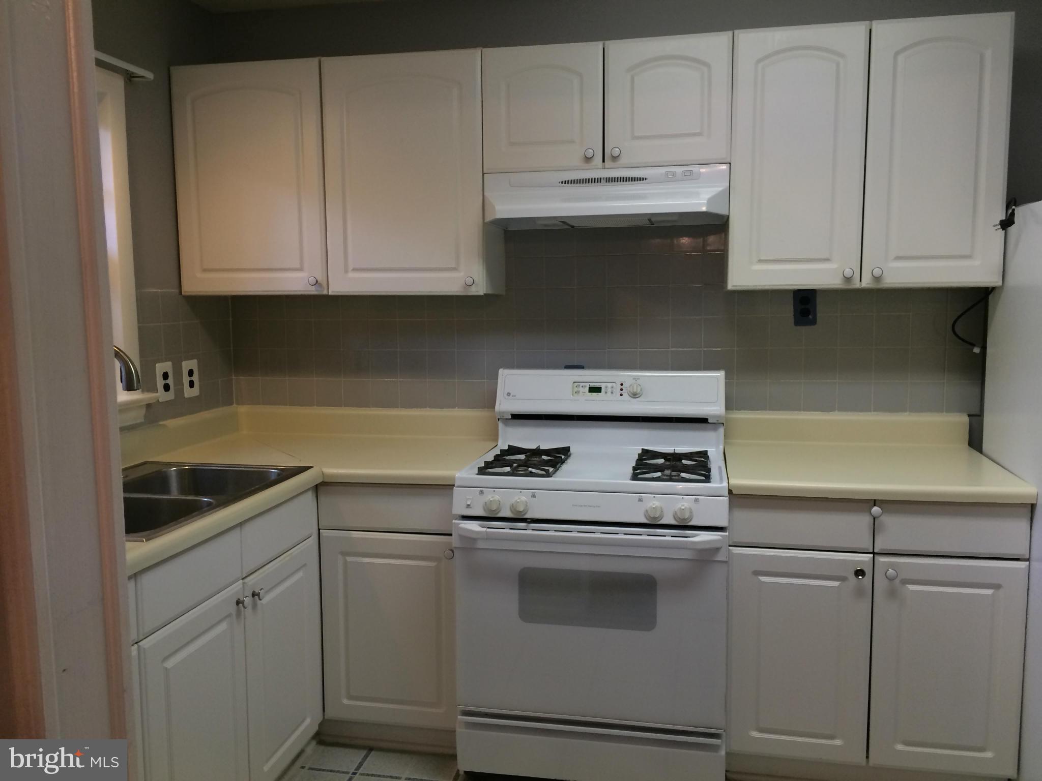 6814 Mayo Court Springfield, VA 22150 - Photo 19 of 30 a kitchen with white cabinets and white appliances