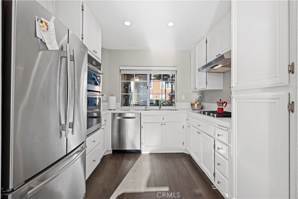 33 Gauguin Circle Aliso Viejo, CA 92656 - Photo 13 of 49 a kitchen with white cabinets and refrigerator