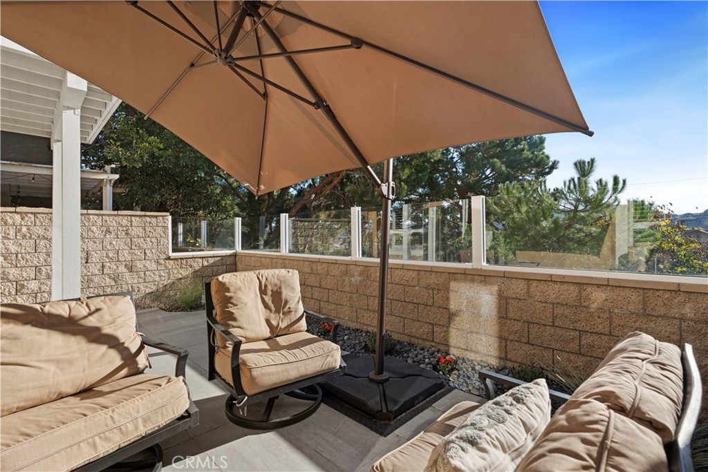 33 Gauguin Circle Aliso Viejo, CA 92656 - Photo 19 of 49 a view of a patio with couches table and chairs under an umbrella